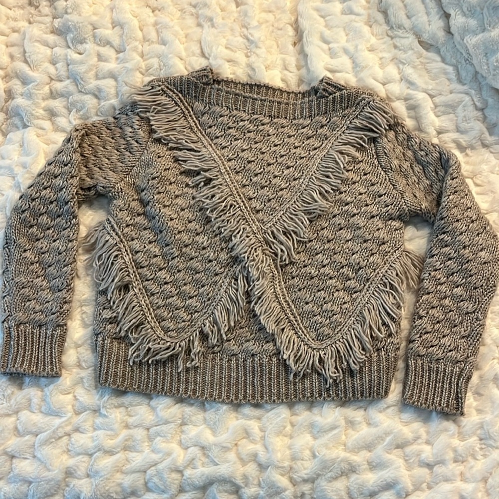 New without tags. Beautiful unique sweater with crisscross fringe detailing.